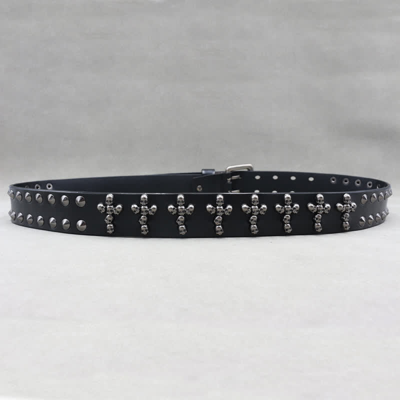 Cinturón de cuero con remaches y doble pasador con forma de cruz y cabezas de calavera.