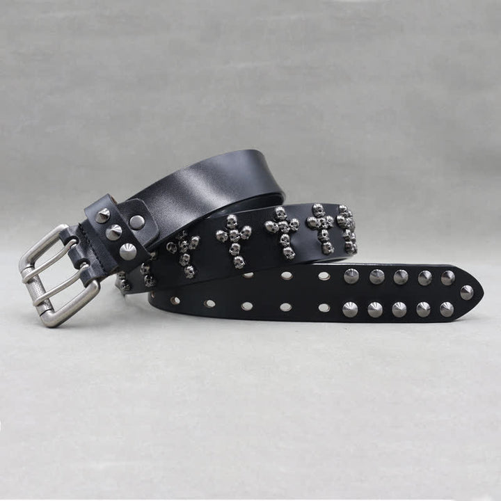 Cinturón de cuero con remaches y doble pasador con forma de cruz y cabezas de calavera.