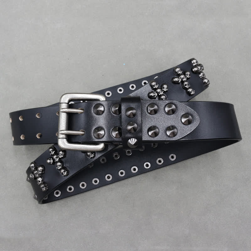 Cinturón de cuero con remaches y doble pasador con forma de cruz y cabezas de calavera.