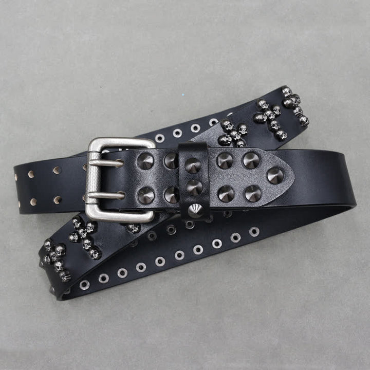 Cinturón de cuero con remaches y doble pasador con forma de cruz y cabezas de calavera.