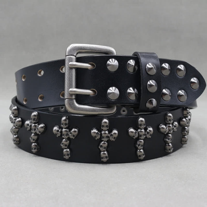 Cinturón de cuero con remaches y doble pasador con forma de cruz y cabezas de calavera.