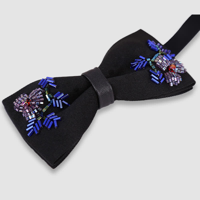 Pajarita negra con bordado de cuentas y forma de flor.