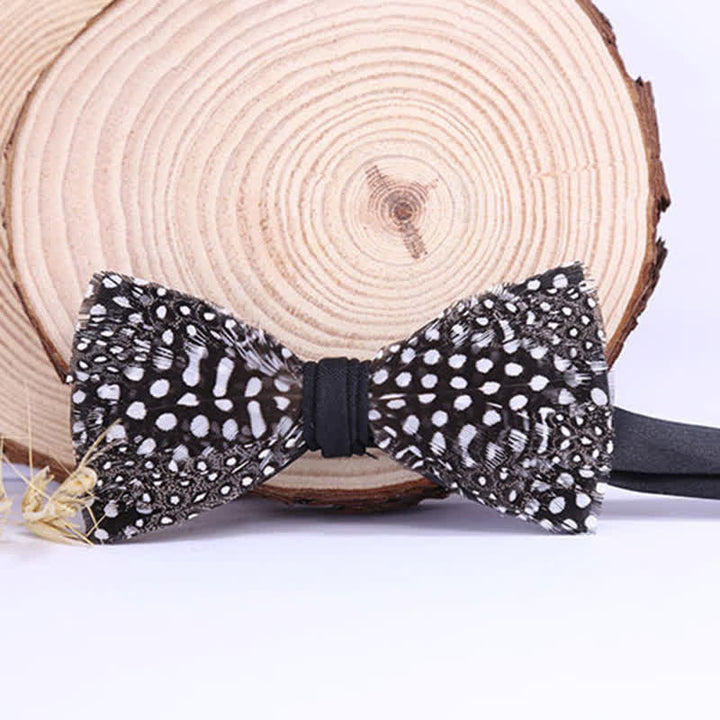 Pajarita con plumas y lunares en blanco y negro con broche de solapa