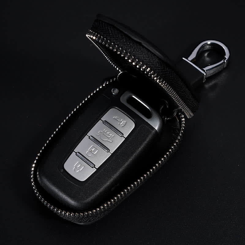 Estuche multifuncional para llaves de coche de cuero con diseño en V y cremallera.