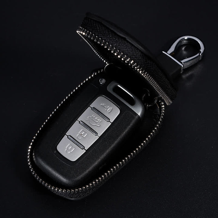 Estuche multifuncional para llaves de coche de cuero con diseño en V y cremallera.