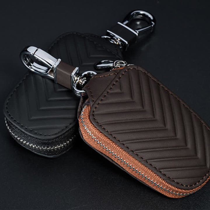 Estuche multifuncional para llaves de coche de cuero con diseño en V y cremallera.