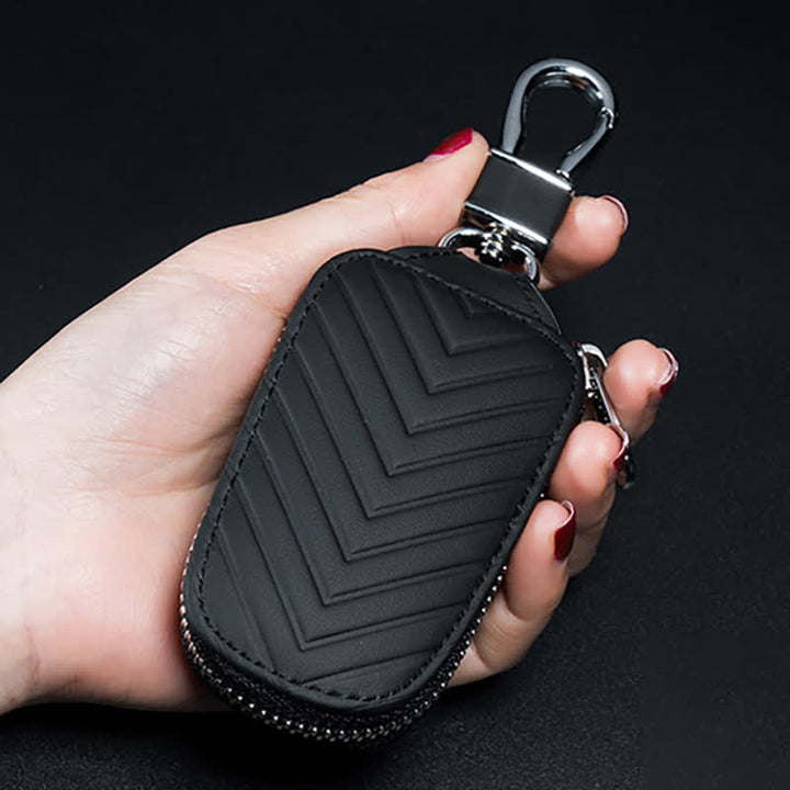 Estuche multifuncional para llaves de coche de cuero con diseño en V y cremallera.