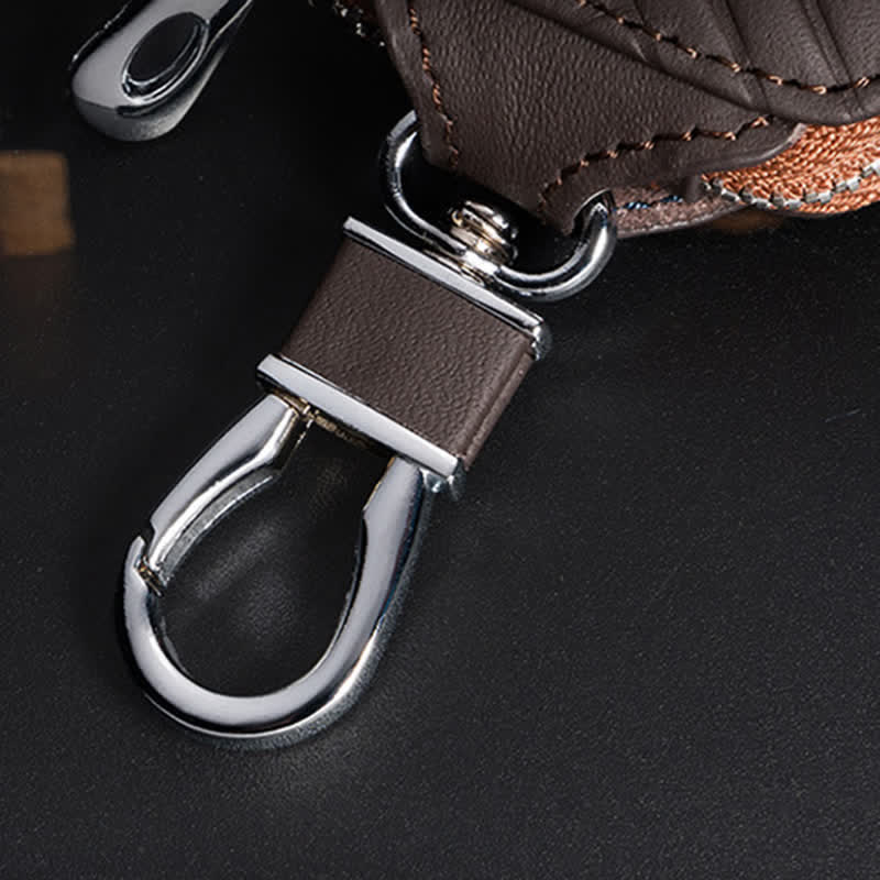 Estuche multifuncional para llaves de coche de cuero con diseño en V y cremallera.