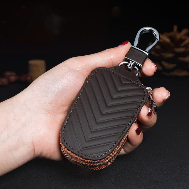 Estuche multifuncional para llaves de coche de cuero con diseño en V y cremallera.