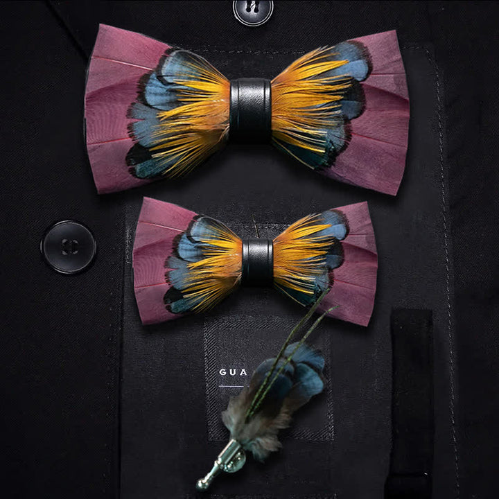 Pajarita con plumas simétricas en color rosa y naranja y broche de solapa