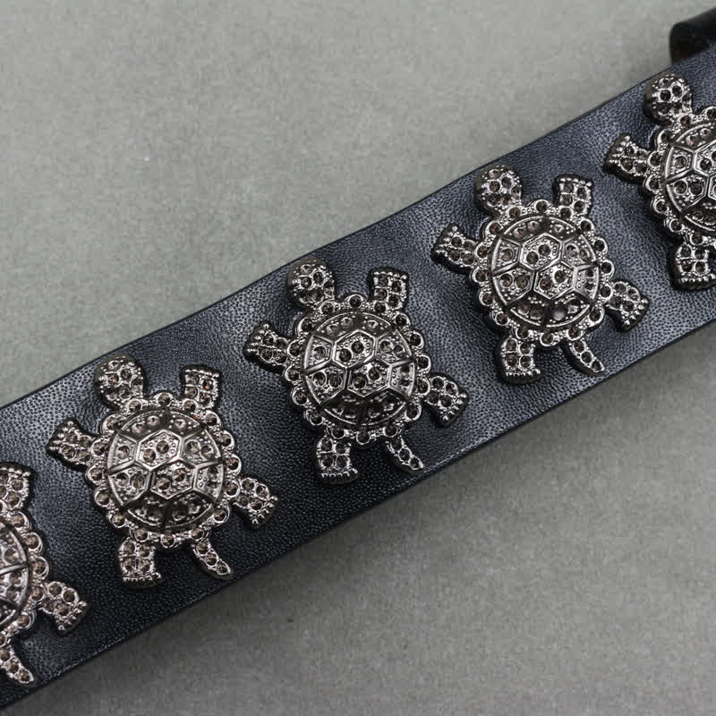 Cinturón de cuero con remaches de tortuga de metal tridimensionales y doble pasador.