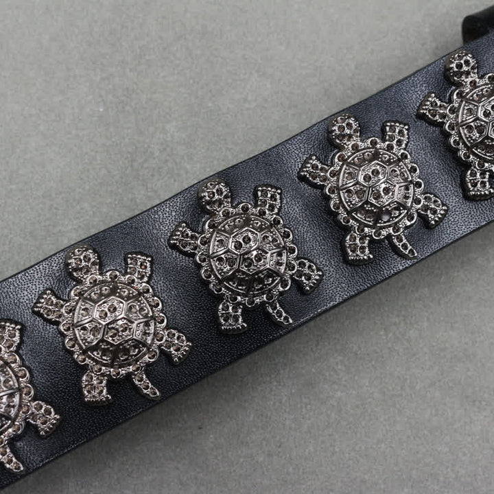 Cinturón de cuero con remaches de tortuga de metal tridimensionales y doble pasador.