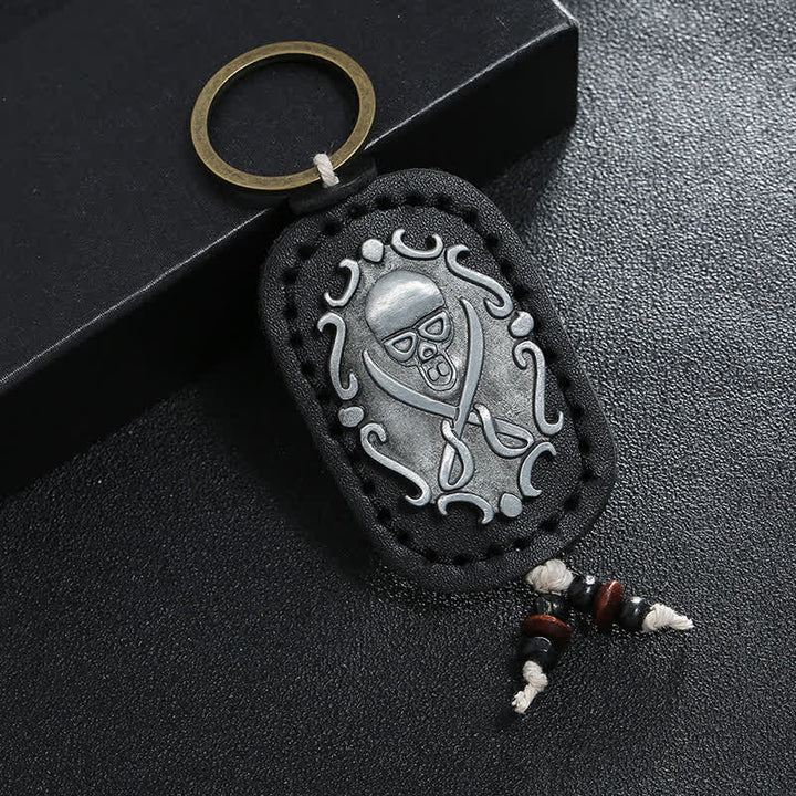Llavero de cuero con colgante de calavera y espadas dobles