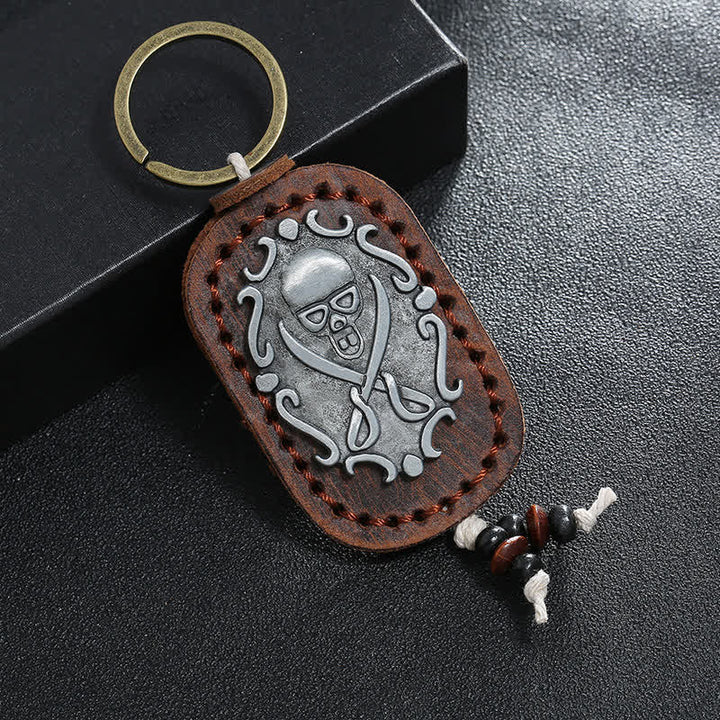 Llavero de cuero con colgante de calavera y espadas dobles