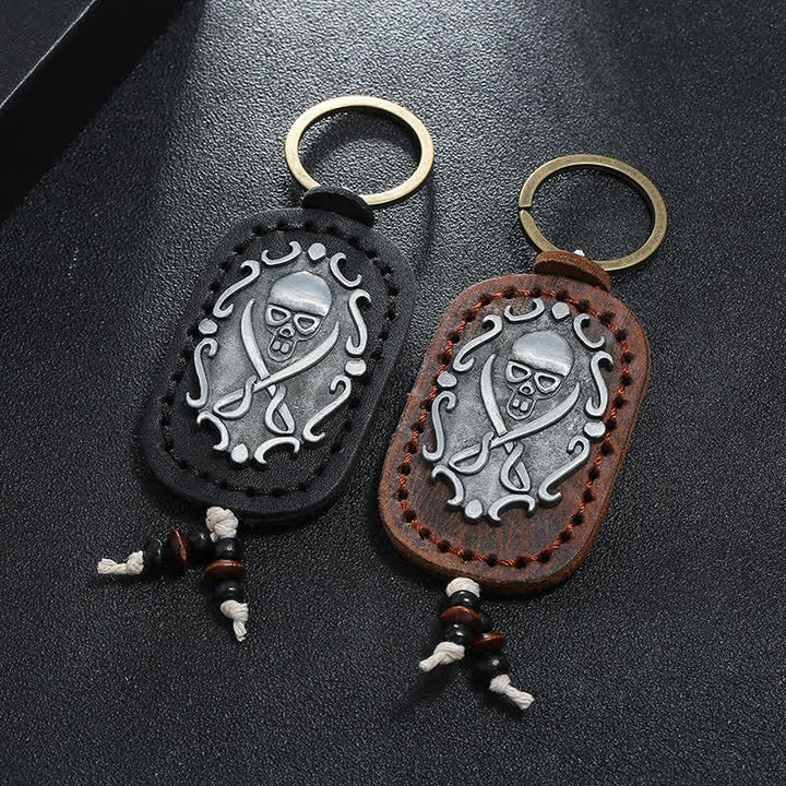 Llavero de cuero con colgante de calavera y espadas dobles