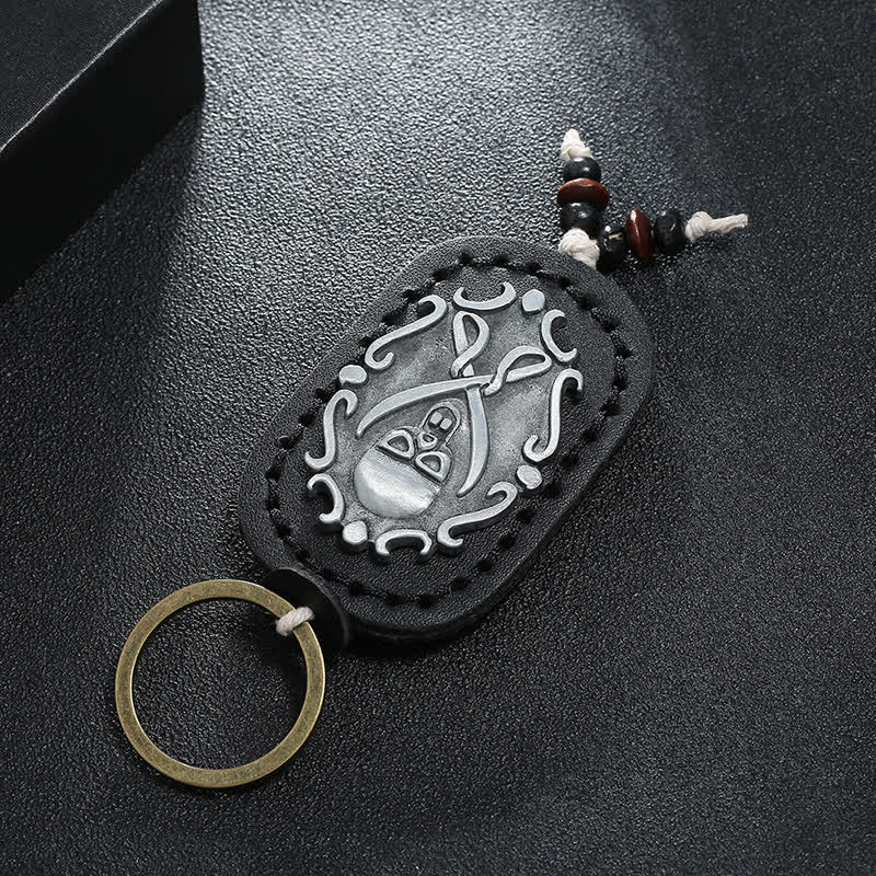 Llavero de cuero con colgante de calavera y espadas dobles