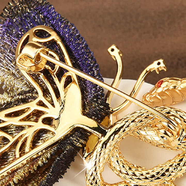 Broche de mujer con mariposa bordada en morado y serpiente dorada