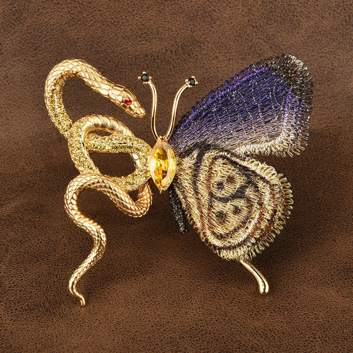 Broche de mujer con mariposa bordada en morado y serpiente dorada