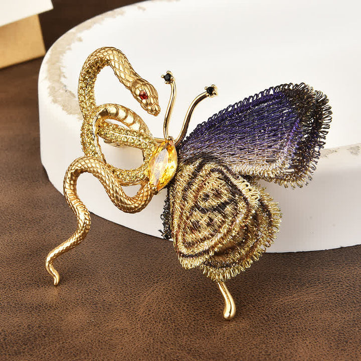 Broche de mujer con mariposa bordada en morado y serpiente dorada