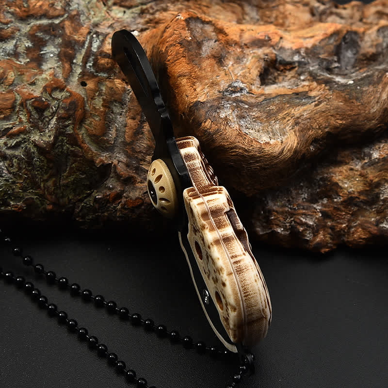 Mini cuchillo plegable con diseño de calavera creativa y llavero con cadena.