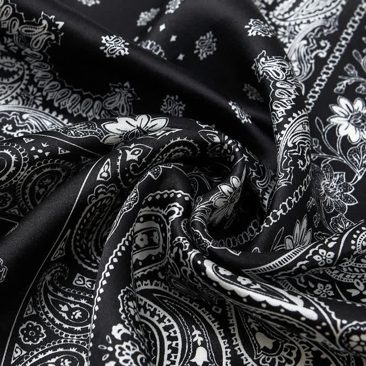 Bufanda cuadrada con diseño de cuadrícula de cuatro cuadros y estampado paisley en blanco y negro.