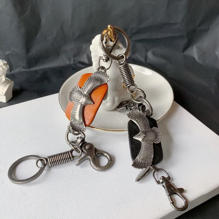 Llavero de cuero con colgante de metal y águila en vuelo