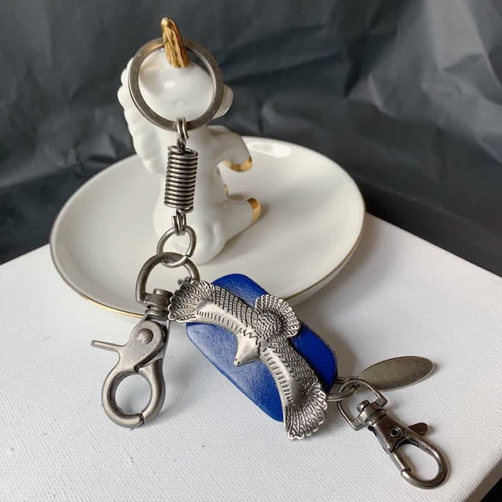 Llavero de cuero con colgante de metal y águila en vuelo