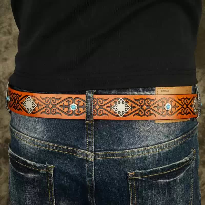 Cinturón de piel con estampado en relieve de color naranja y aspecto étnico.