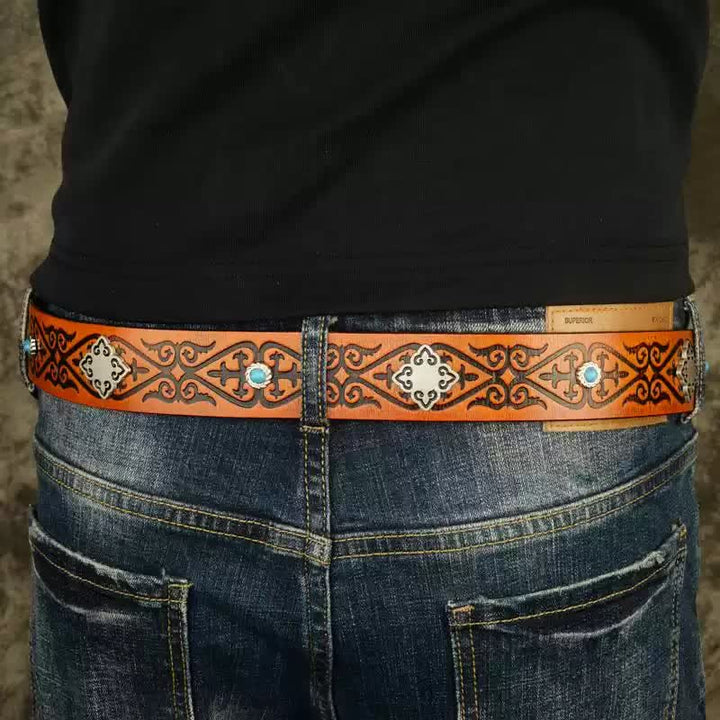 Cinturón de piel con estampado en relieve de color naranja y aspecto étnico.