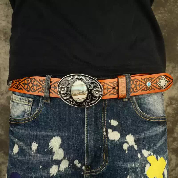 Cinturón de piel con estampado en relieve de color naranja y aspecto étnico.