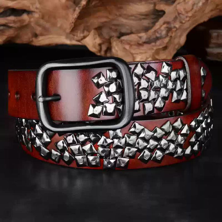 Cinturón de cuero con remaches piramidales brillantes y diseño irregular