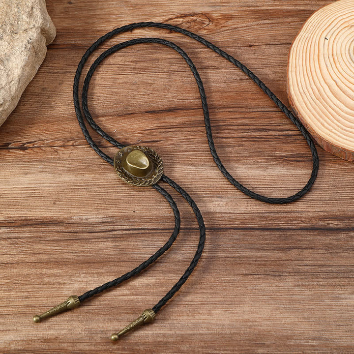 Dije de bronce con forma de sombrero de vaquero y corbata de bolo