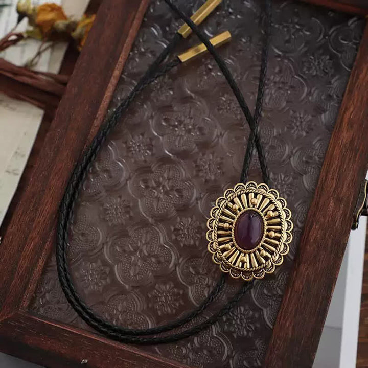 Corbata bolo de resina roja oscura con medallón dorado antiguo