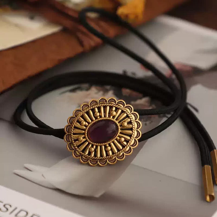 Corbata bolo de resina roja oscura con medallón dorado antiguo