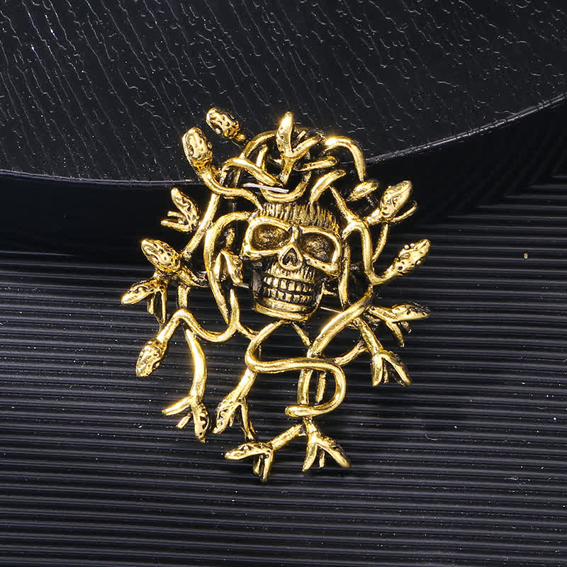 Broche exagerado de calavera con cabeza de serpiente envuelta