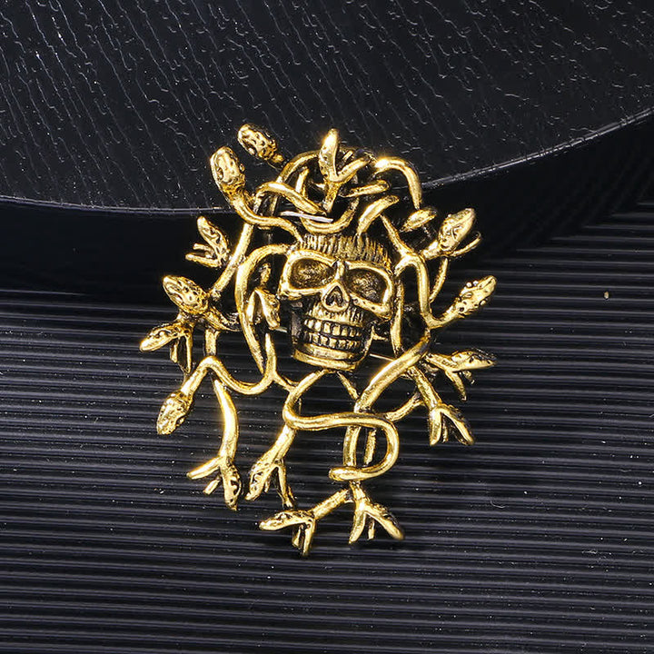 Broche exagerado de calavera con cabeza de serpiente envuelta