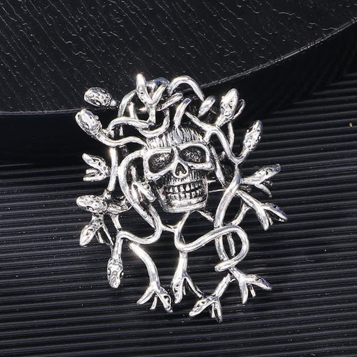Broche exagerado de calavera con cabeza de serpiente envuelta
