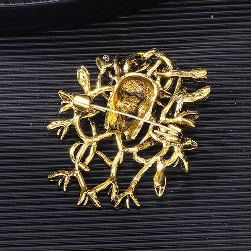 Broche exagerado de calavera con cabeza de serpiente envuelta