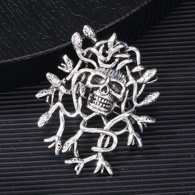 Broche exagerado de calavera con cabeza de serpiente envuelta