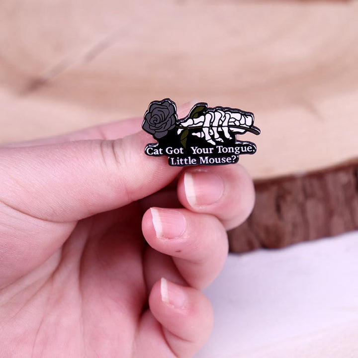 Broche de esmalte con forma de esqueleto de rosa y ratón con el gato comiéndose la lengua
