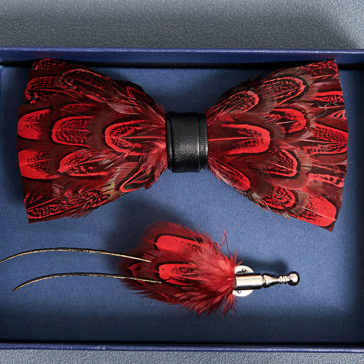 Pajarita con plumas de pavo real crisón y negras y broche de solapa