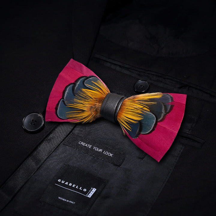 Pajarita con plumas simétricas en color rosa y naranja y broche de solapa