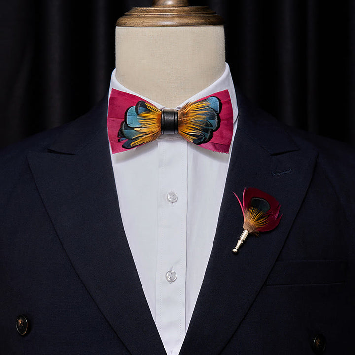 Pajarita con plumas simétricas en color rosa y naranja y broche de solapa