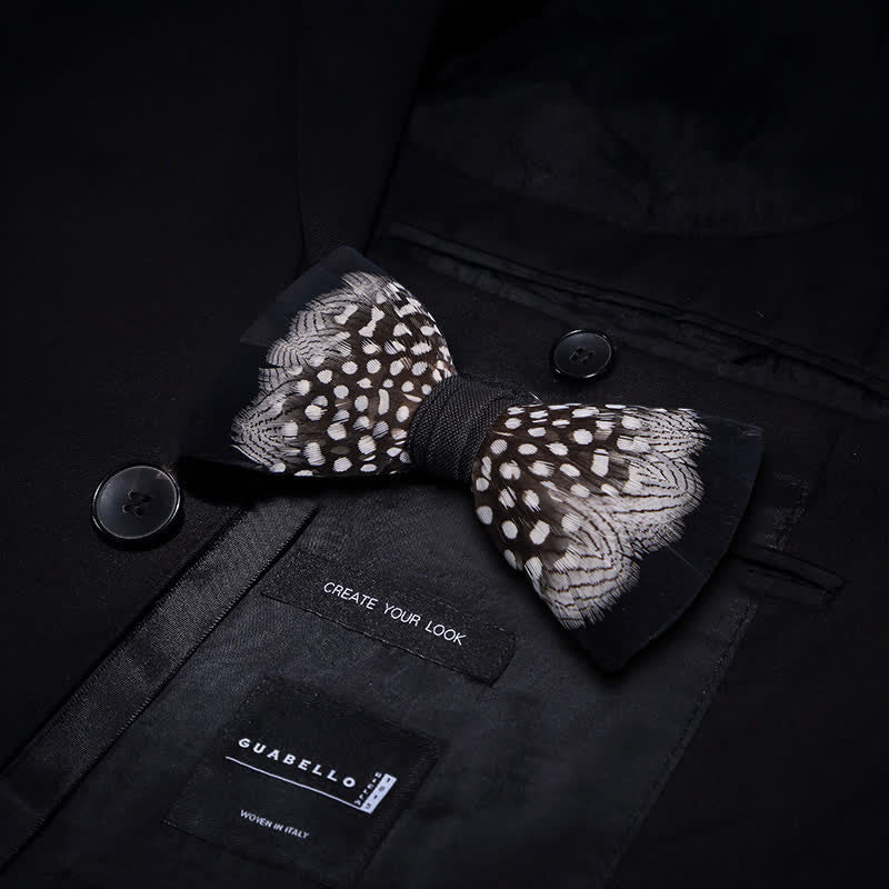 Pajarita de plumas entrelazadas en blanco y negro con prendedor de solapa