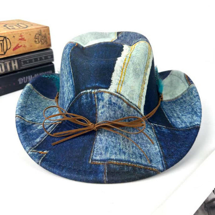 Sombrero vaquero de mezclilla con diseño de bloques de color y plumas verdes.