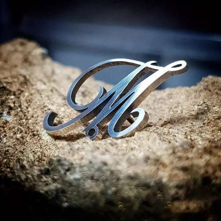 Broche elegante con iniciales personalizados y cadena.