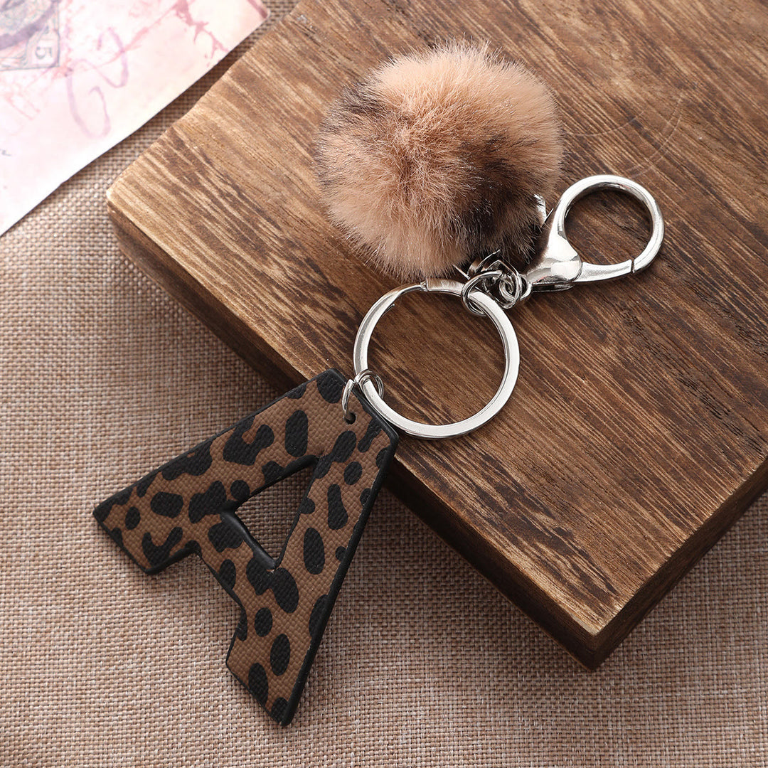 Llavero de cuero con letras y estampado de leopardo estilo occidental con bola de peluche - image 1