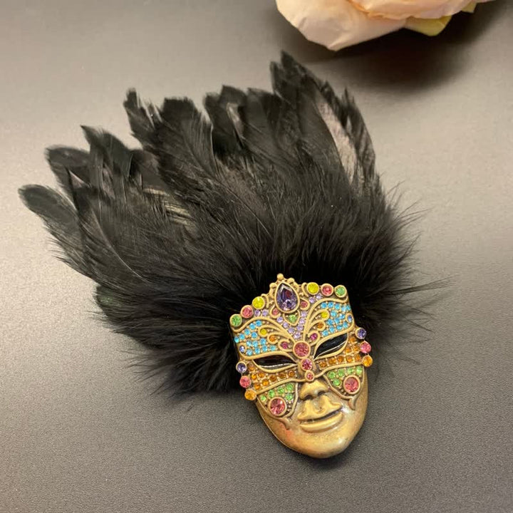 Broche de plumas con máscara de tribus primitivas