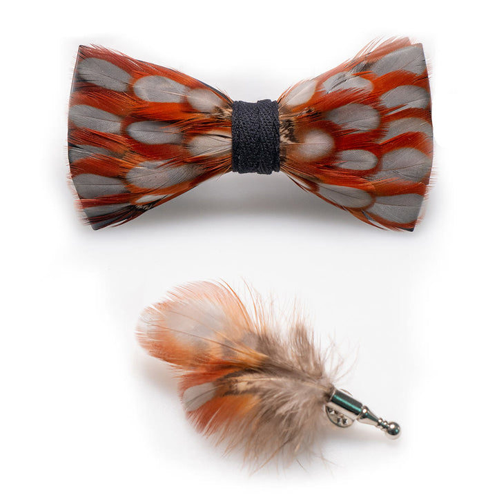 Pajarita de plumas cálidas de color naranja y blanco con broche de solapa