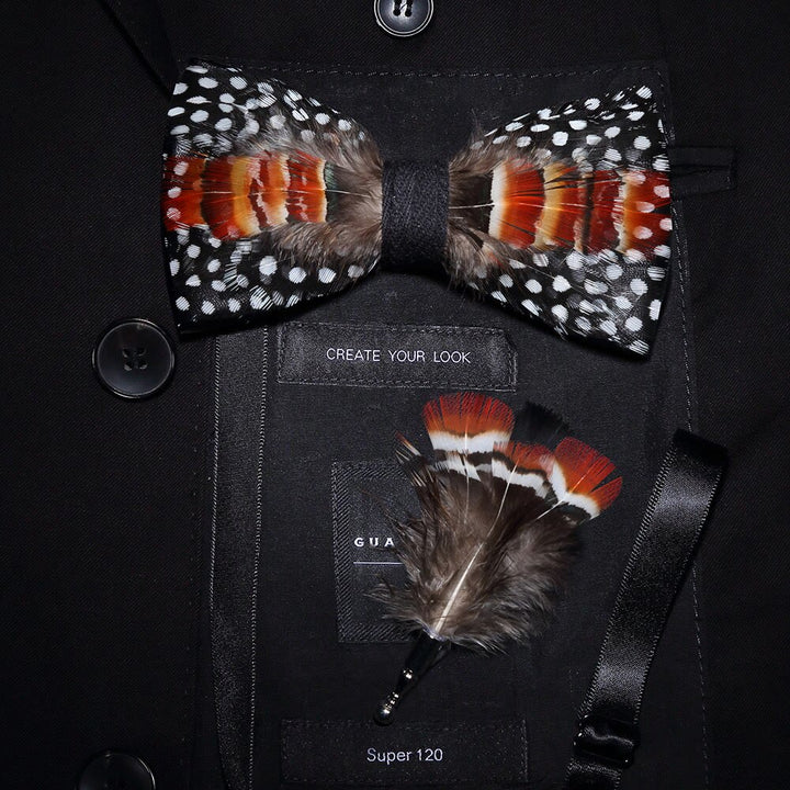 Pajarita con plumas de lunares en blanco, naranja y negro y broche de solapa